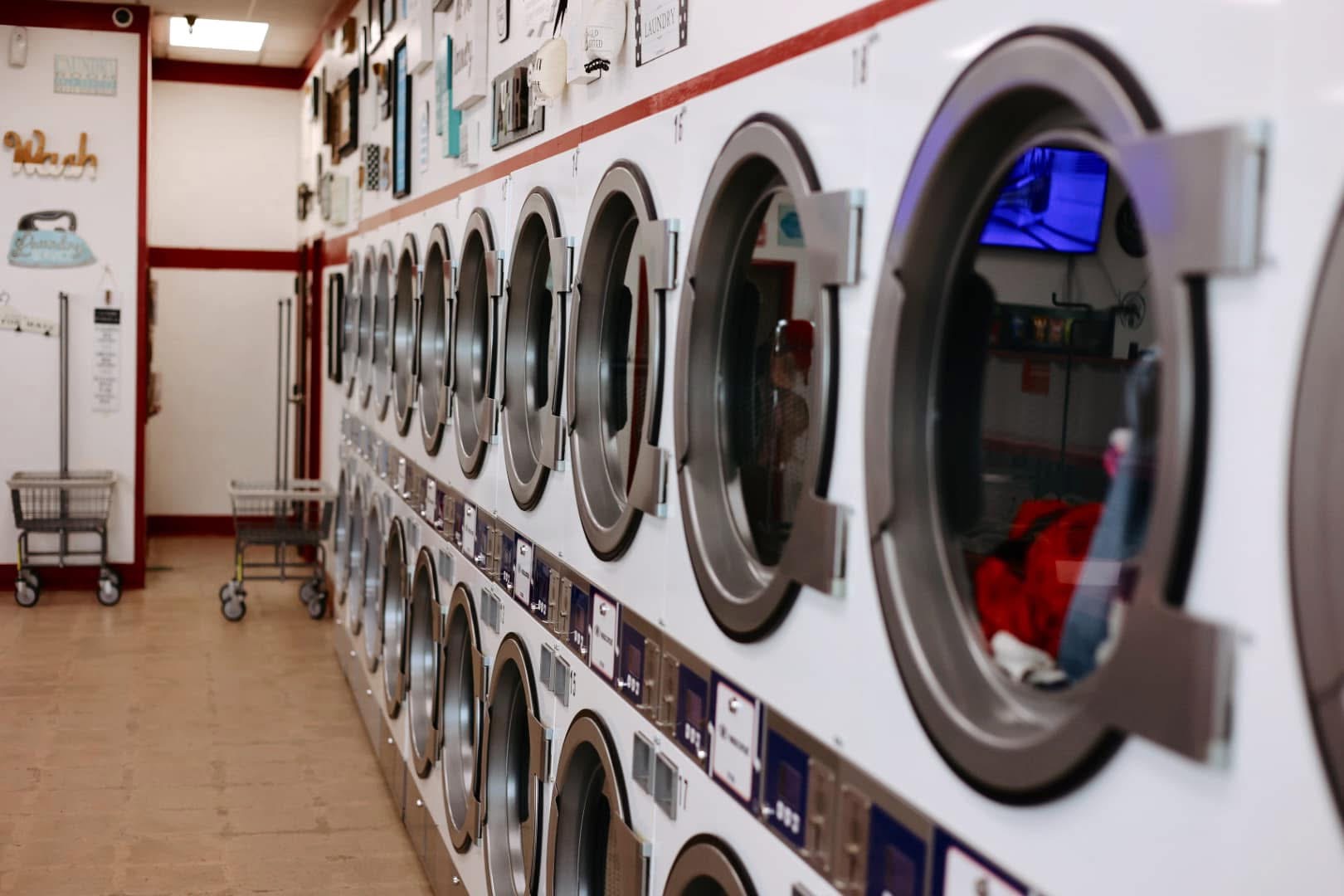 A row of large-capacity dryers inside Laura's Laundromat